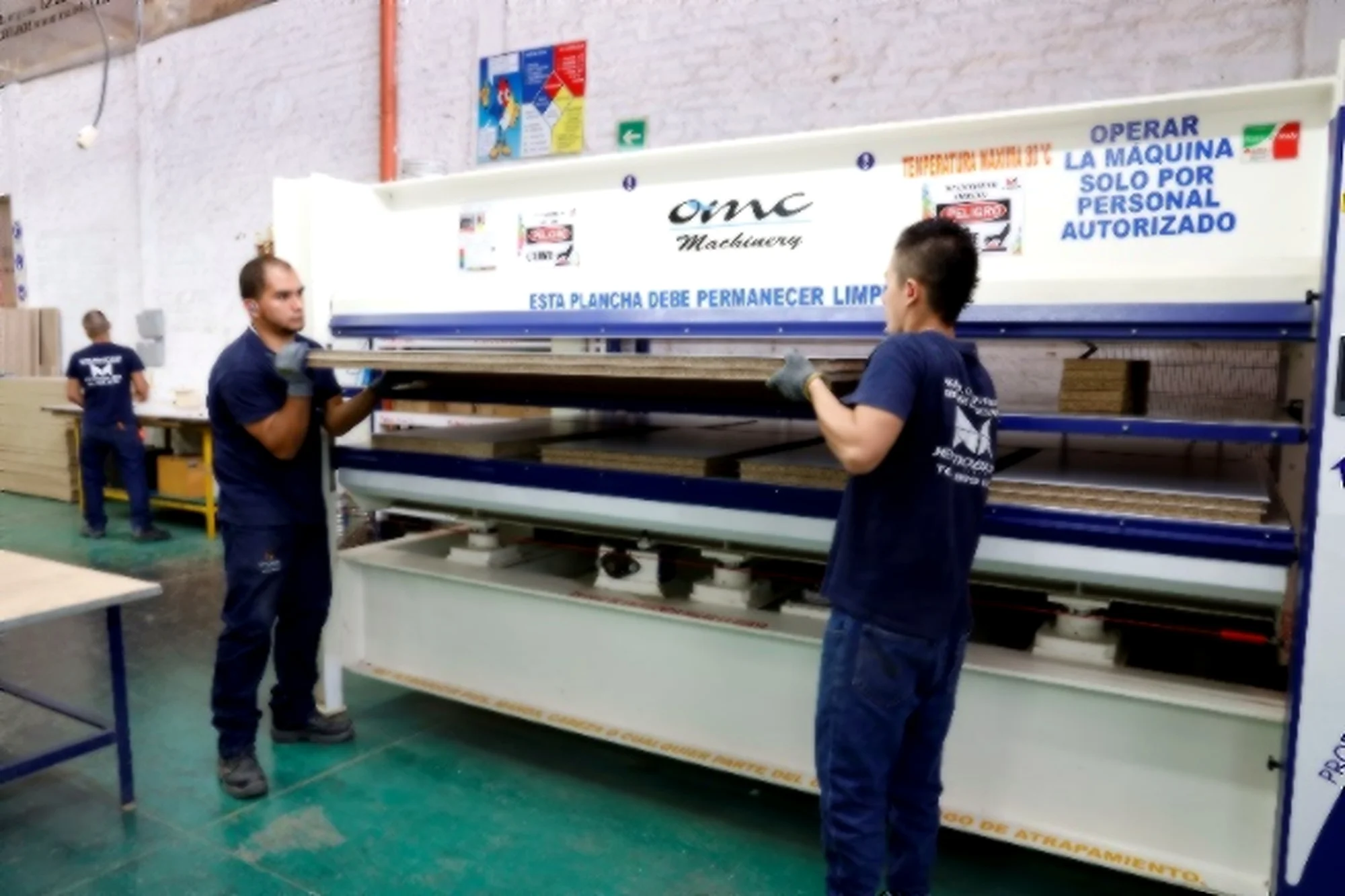 Equipo de JEP operando una prensa en la planta